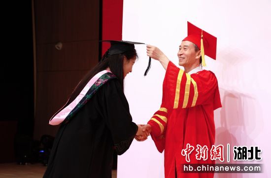 孔建益校长为学生拨穗 胡毅 摄 孔建益校长为学生拨穗 胡毅 摄